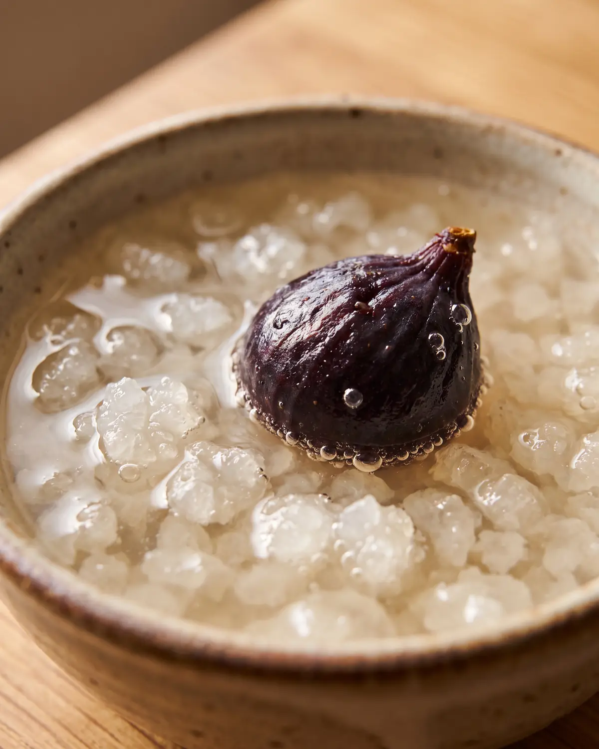 grains de kéfir tibicos Détail d’une figue réhydratée flottant sur les grains de kéfir d’eau, avec de fines bulles visibles.
